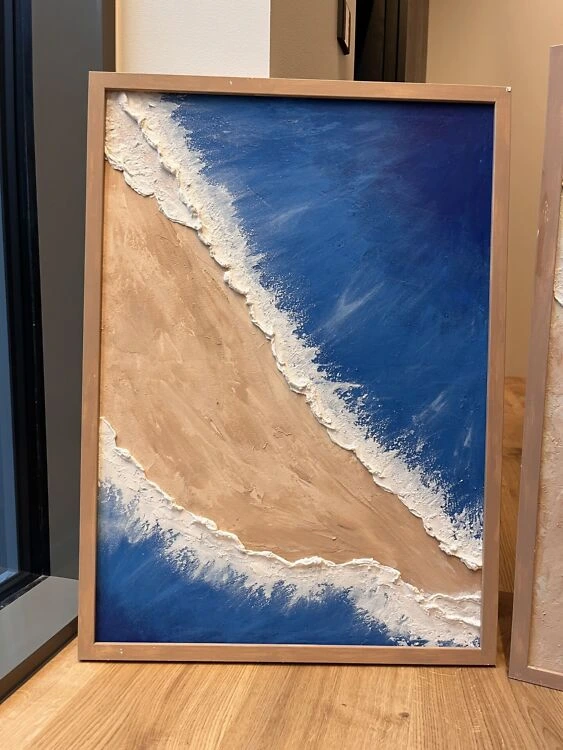 Teine maal seeriast "Sandy Beach". 50x70 cm teos, kus sügavsinine vesi ja liivakarva pruun kohtuvad kahe dünaamilise valge vahuse veeribaga.