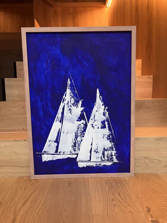 Abstraktne akrüülmaal 'Deep Blue Midnight Sailing', kus tumesinisel südaöisel merel seilavad kontrastsed valged purjekad sügava sinise taeva taustal.