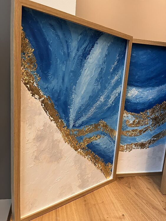 Struktuurse tekstuuriga akrüülmaal, kus ülevalt vasakult alla paremale jookseb lai ja paks kuldlehest diagonaaljoon sinisel ja beezil taustal.