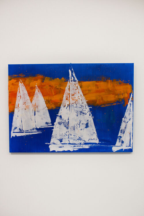 Akrüülmaal lõuendil, kus kujutatud valgete purjedega purjekaid sügavsinisel merel, taustal intensiivne oranž päikeseloojang