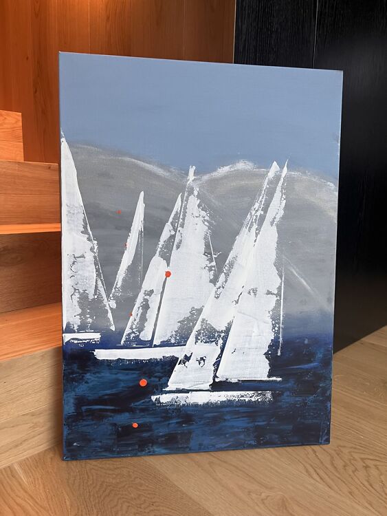 Akrüülmaal sinistes ja valgetes toonides, kus tumedal veepinnal sõidavad valged purjekad ning taustal kõrgub massiivne hõbedaselt läikiv kivimägi.