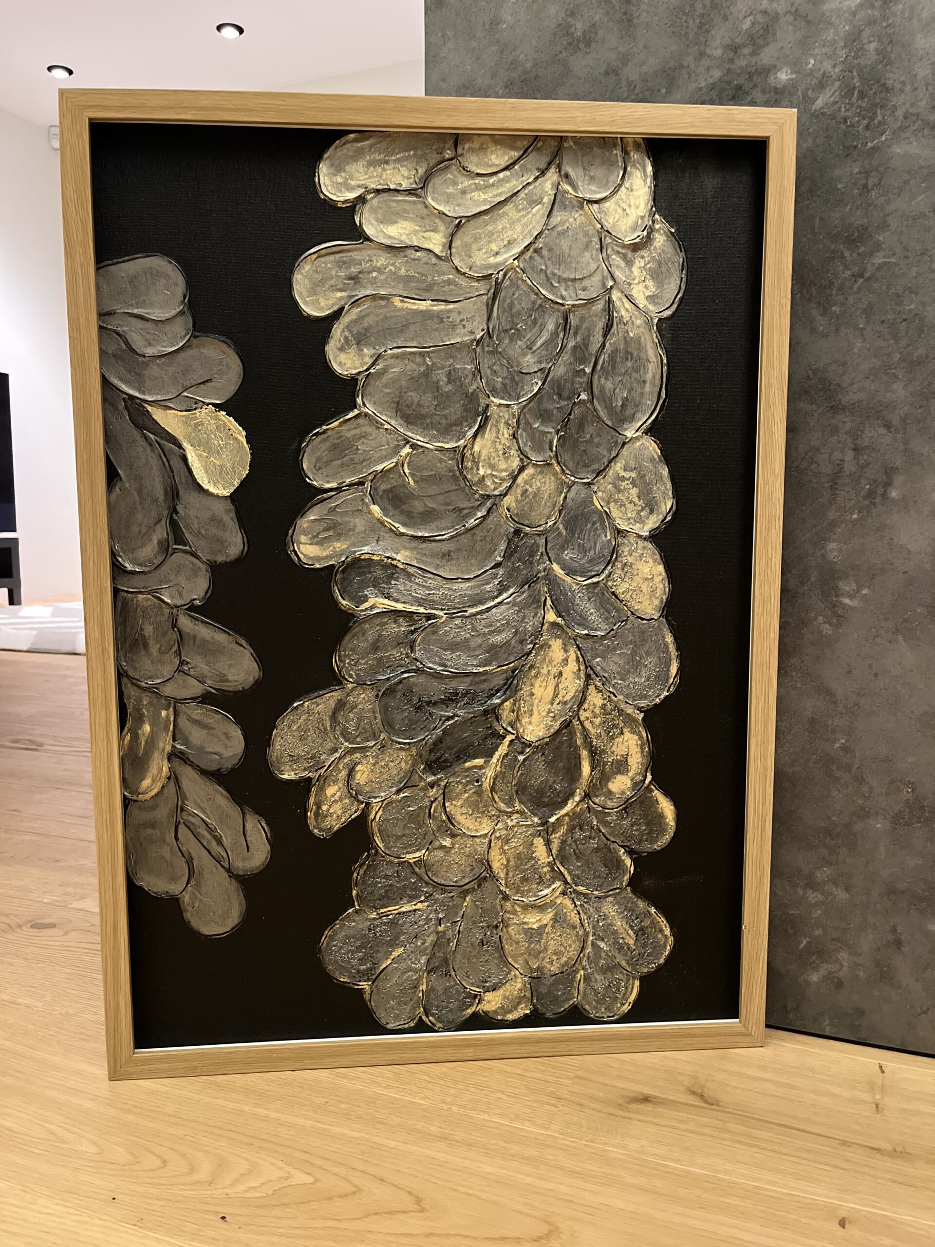 Struktuurne akrüülmaal Golden Flower, kus mustal taustal on kujutatud reljeefsed kuldsed lilled. Luksuslik ja sügava tekstuuriga seinakunst.