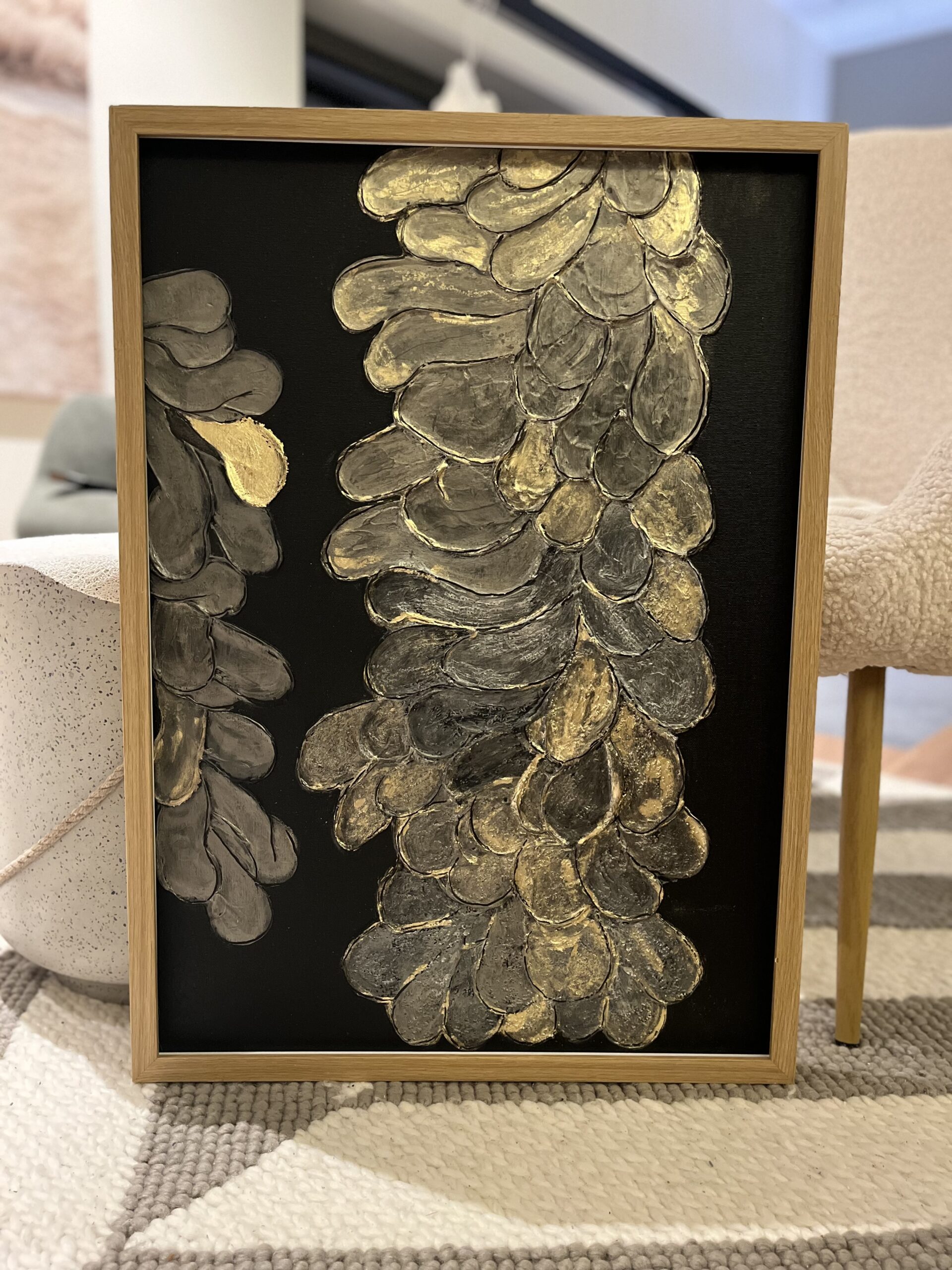 Struktuurne akrüülmaal Golden Flower, kus mustal taustal on kujutatud reljeefsed kuldsed lilled. Luksuslik ja sügava tekstuuriga seinakunst.